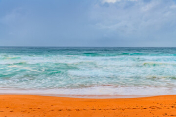 Moody sunrise with waves at the seaside