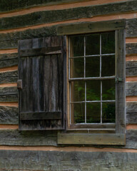 A window with a shutter in a old log cabin