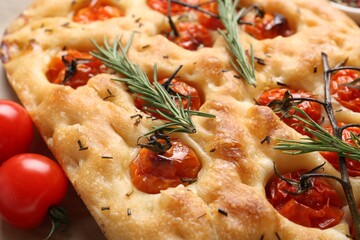 Delicious focaccia with tomatoes and spices on table, closeup