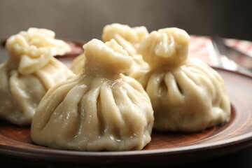 Delicious cooked khinkali served on table, closeup