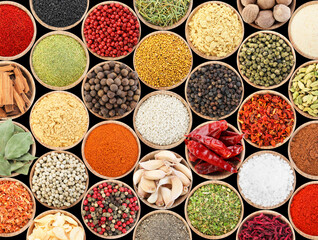 Set of different aromatic spices in bowls on black background, flat lay