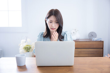 Cute woman lost in her room thinking and worrying about her computer A little serious negative image Surprised and surprised expression