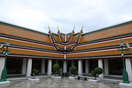 A colorful Wat Suthat Thepwararam temple with ornate roof tiles, golden chofas, and symmetrical architecture stands above a courtyard on June 14, 2025 in Bangkok, Thailand.