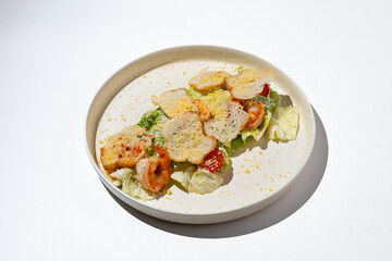 A vibrant salad is beautifully presented on a minimalist plate, showcasing succulent shrimp, crisp vegetables, and delicate garnishes. The setting highlights the culinary artistry and freshness