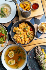 A tantalizing spread of dishes features handmade pasta, fresh salads, rich soups, frying delicacies, and vibrant garnishes, creating an enticing dining experience for food lovers