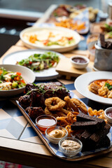 An enticing spread of dishes fills the wooden table, featuring crispy appetizers, fresh salads, and...