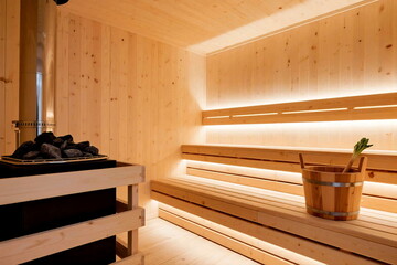Traditional Wooden Sauna Interior with Heater and Water Bucket in Corner
