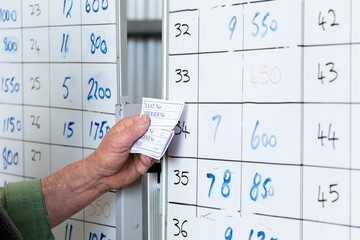 Hand holding cards with numbers on whiteboard