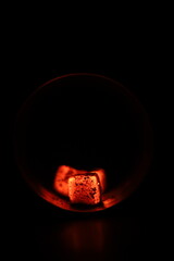 Glowing coals with glitch style lighting, enriched by noise, effect and grain details, create a mystical atmosphere in the dark. A vivid sense of heat and depth surrounds the image