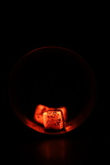 Glowing coals with glitch style lighting, enriched by noise, effect and grain details, create a mystical atmosphere in the dark. A vivid sense of heat and depth surrounds the image
