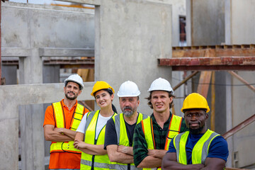 A group of civil engineers from different ethnicities and experiences stands with arms crossed...