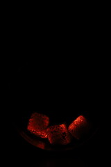 Glowing coals with glitch style lighting, enriched by noise, effect and grain details, create a mystical atmosphere in the dark. A vivid sense of heat and depth surrounds the image