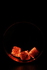 Glowing coals with glitch style lighting, enriched by noise, effect and grain details, create a mystical atmosphere in the dark. A vivid sense of heat and depth surrounds the image