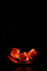Glowing coals with glitch style lighting, enriched by noise, effect and grain details, create a mystical atmosphere in the dark. A vivid sense of heat and depth surrounds the image