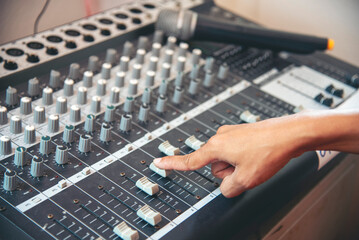 Production sound engineer woman hands adjusting volume equalizer voice, mixing console. DJ sound...