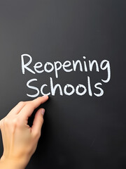 Fototapeta premium A hand writing 'Reopening Schools' on chalk board for schools reopening plans after Covid-19 (Coronavirus) pandemic lockdown.