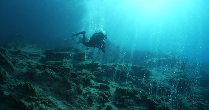 bubbles coming out of a cave underwater scuba divers to explore and enjoy