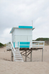 Obraz premium On a sunless day, the light blue and white lifeguard cabin contrasts with the dune landscape.