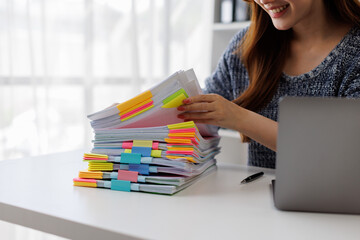 Business Documents, Business woman working in Stacks of paper files for searching and checking...