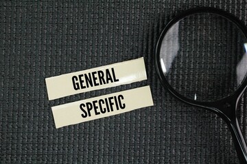 Magnifying glass and paper with the words general or specific. Genera refers to broad categories or overall ideas, while specific refers to particular details or instances