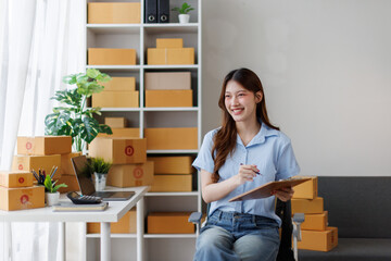 Young attractive asian woman sme owner startup business work happy with box at home prepare parcel...