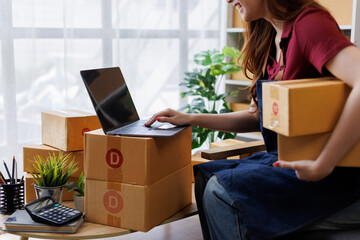 Happy asian business sme entrepreneur owner is smiling while taking notes in her office full of...