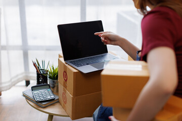 Happy asian business sme entrepreneur owner is smiling while taking notes in her office full of...