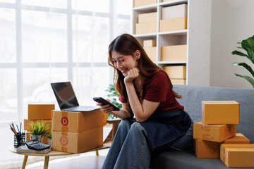 Young asia Small and Medium Enterprises (SMEs) seller woman happy work on laptop busy cellphone...