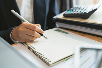 Businessperson writer signing the book and the documents on the table.