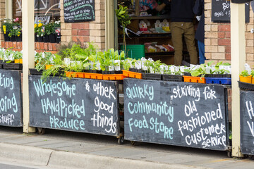 Chalkboard signs on the footpath in front of a produce store
