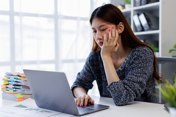 Young asian woman accountant employee Upset stressed guy suffering job problems working on laptop,...