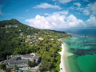 Aerial view of luxury tropical beachfront resort with pristine white sand beach, turquoise lagoon &...