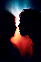 Emotional manipulation psychology relationship. A person whispers into another's ear amidst a conflict scene.