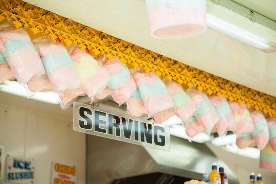 Colourful fairy floss hanging above serving sign in sideshow alley