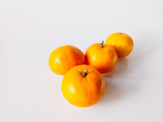 small pile of fresh brightly colored oranges with textured skin, isolated on a clean white background, ideal for healthy eating and fruit-related themes