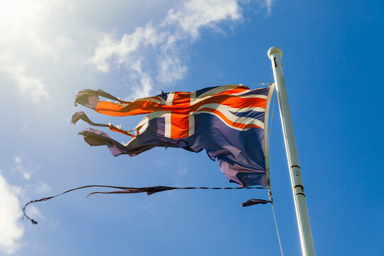 Tattered Australian flag against blue sky