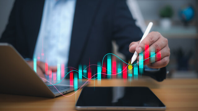 A businessman uses a stylus to analyze a dynamic, fluctuating financial graph with red and blue bars, symbolizing investment analysis, stock market trends, and data driven decision making.