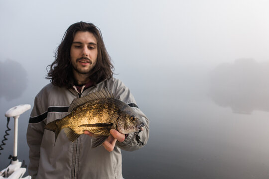 Young Man holding a Bream he Just Caught