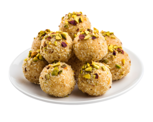 Traditional Indian coconut pistachio laddu sweet balls served on a white plate isolated on transparent background