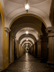 Fototapeta premium Historic stone corridor with arches and lamps in Antigua Guatemala showcasing charming architecture