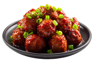Close up of spicy meatballs coated in rich red sauce garnished with chopped green onions served on black plate isolated on transparent background