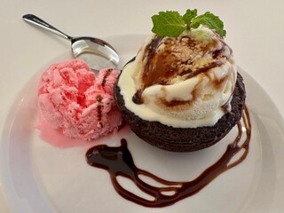 A portion of chocolate lava cake with ice cream and special sauce