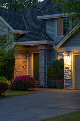 Obraz premium Entrance of luxury house with nice spring blossom landscape at night in Vancouver, Canada, North America. May 2025.