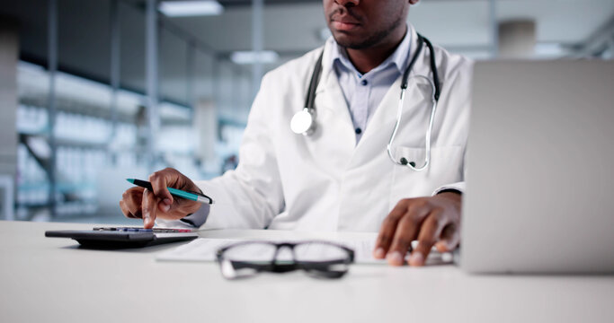 African-American Doctor Calculating Tax Invoice