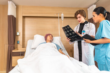 Asian man cancer patient visiting young female doctor for medical consultation in clinic. male patient struggling with cancer, healthcare. Medicine concept.Female doctor explaining xray to patient.