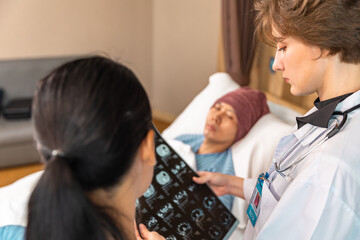 Asian man cancer patient visiting young female doctor for medical consultation in clinic. male...