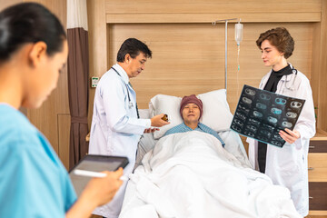 Asian man cancer patient visiting young female doctor for medical consultation in clinic. male patient struggling with cancer, healthcare. Medicine concept.Female doctor explaining xray to patient.