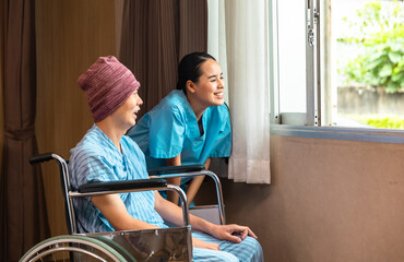 Cancer man patients in wheelchairs receive rehabilitation treatment at clinic. Young female doctor medical therapy treatments.Young patient with a smiling and friendly expression.