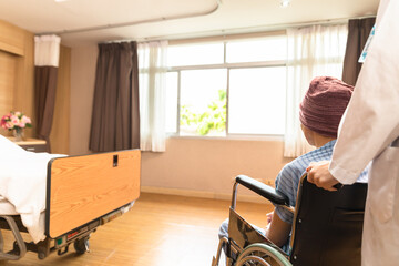 Cancer man patients in wheelchairs receive rehabilitation treatment at clinic. Young female doctor medical therapy treatments.Young patient with a smiling and friendly expression.