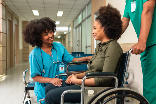 Young  African woman in a wheelchair. Professional young African  doctor  and patient in a nursing home. Assistance, rehabilitation and health care.